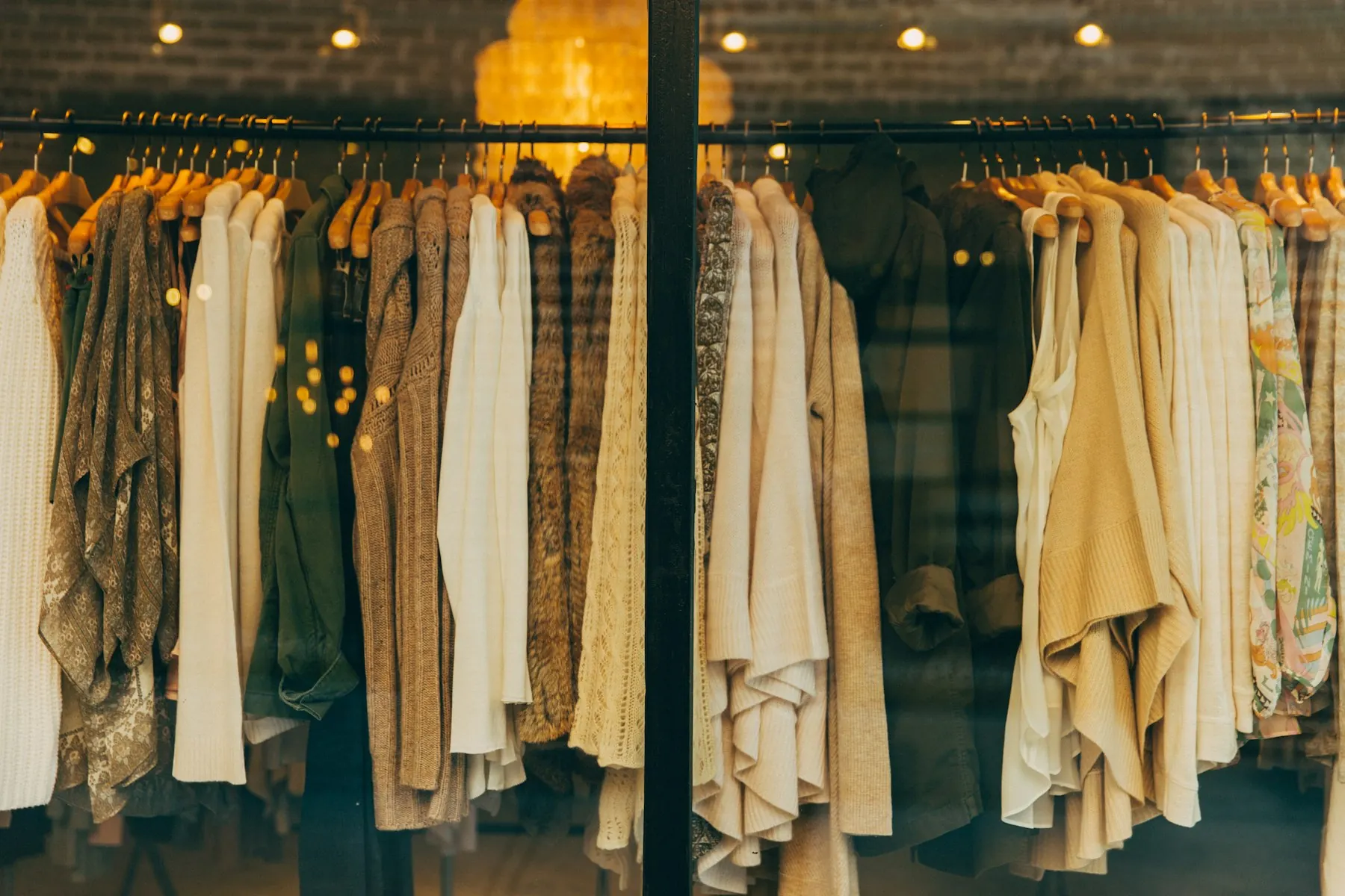 AWAI の店内。生成りやベージュの服がハンガーに並ぶ