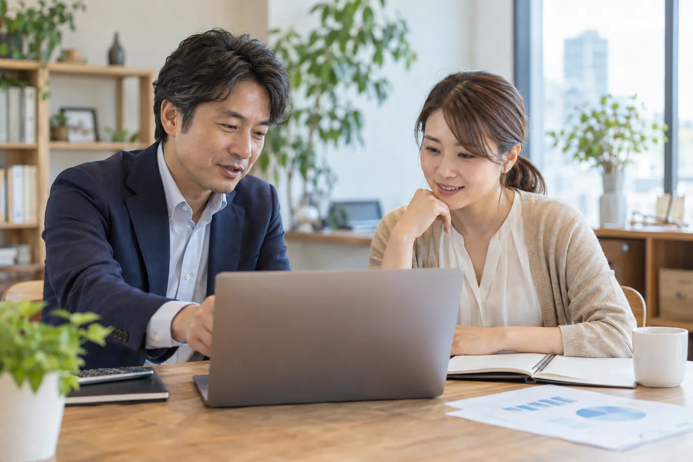 ノートパソコンの試算表を見ながら経営者と月次の数字を確認する税理士
